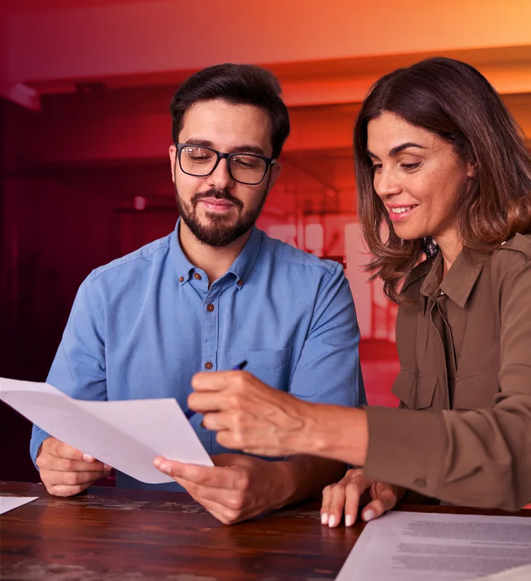 Two clinical research professionals reviewing trial documents together at a desk