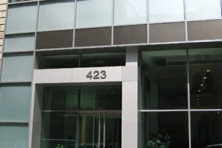 Modern glass building entrance with the street number 423 above the doors.